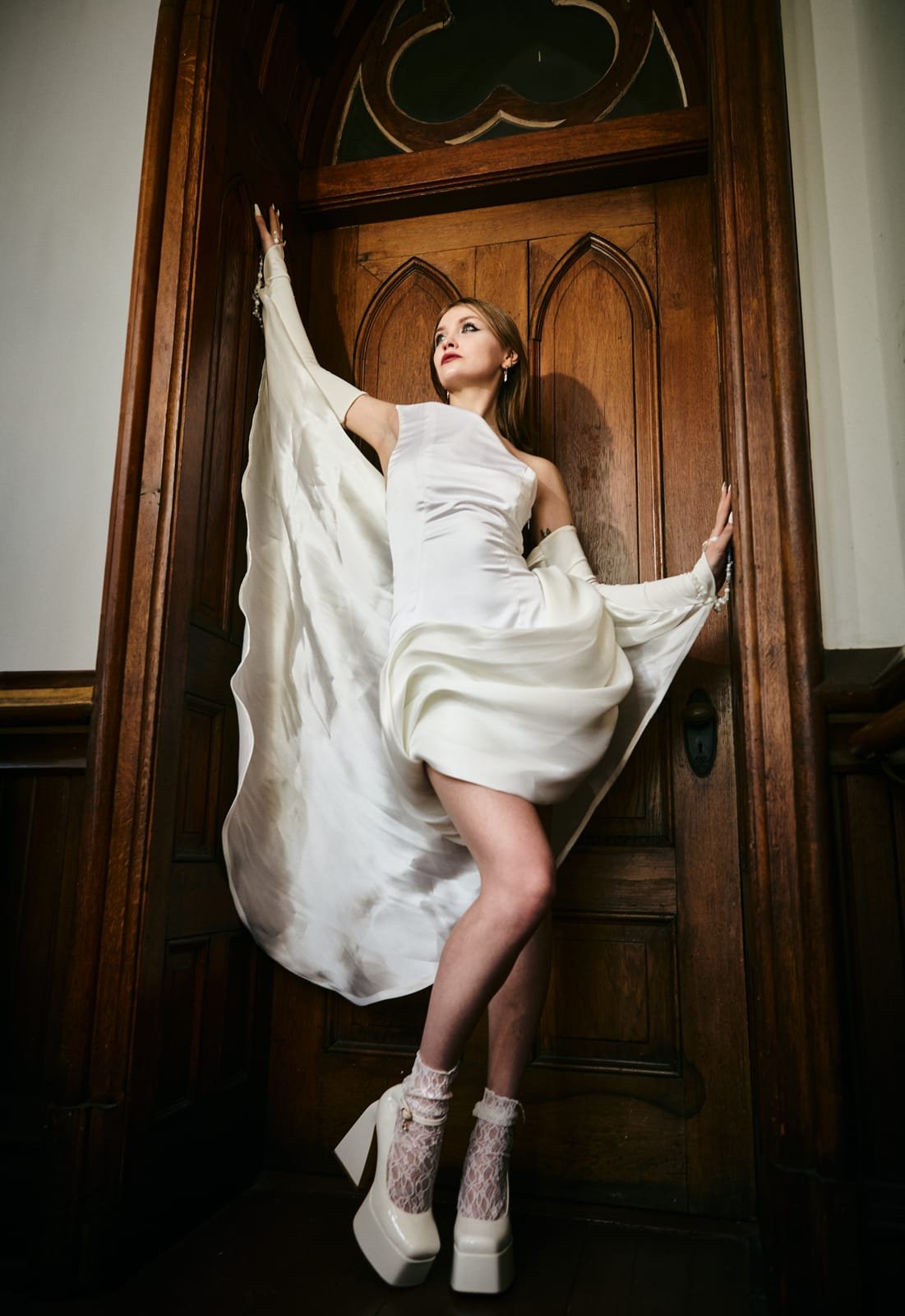 Model in a white gown in a gothic church doorway, from the Convictions collection